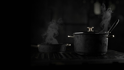 Des casseroles et articles de cuisson noirs, disposés sur une cuisinière