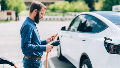 Homme rechargeant une voiture électrique