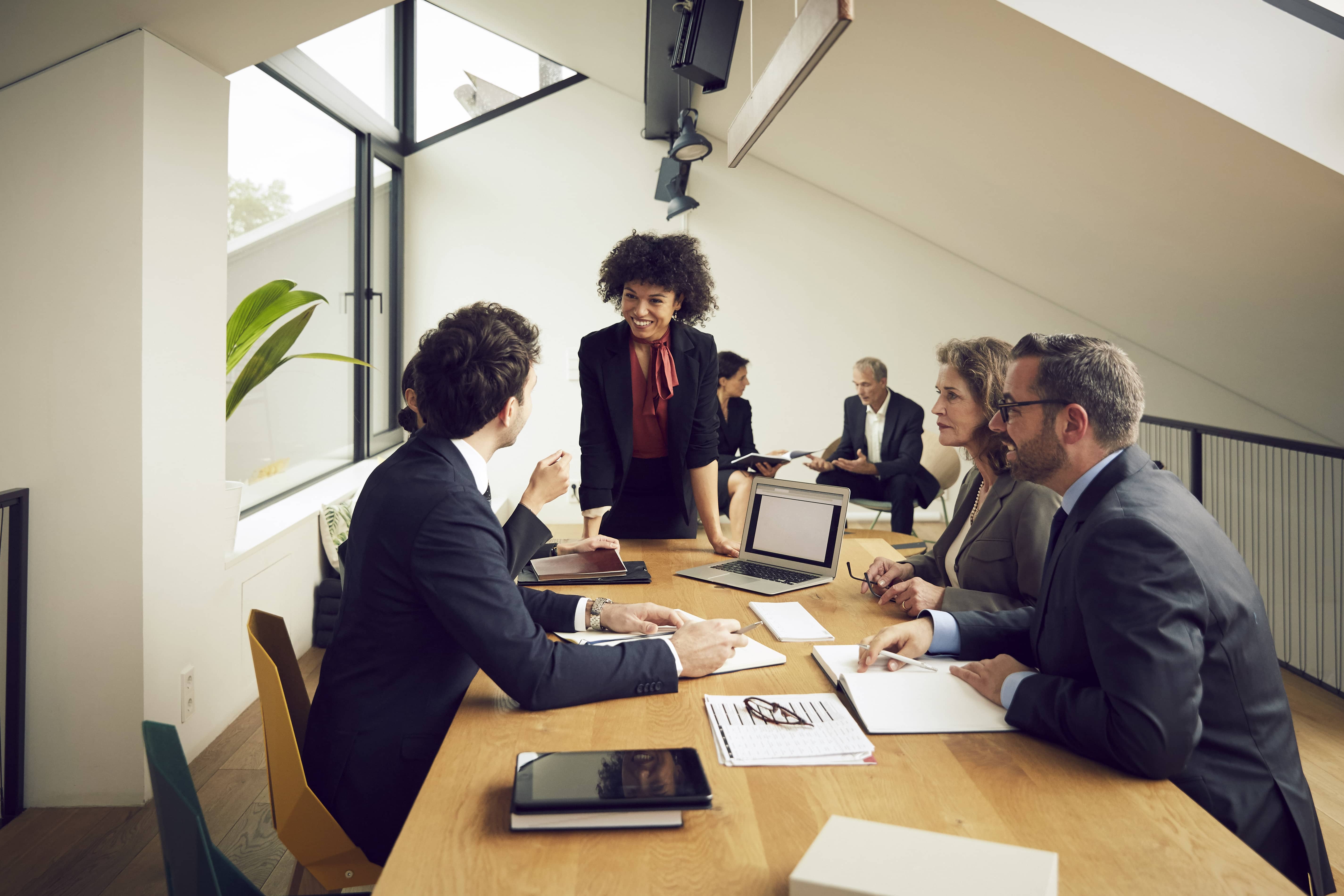 Un groupe de professionnels discutant dans une salle de réunion moderne.